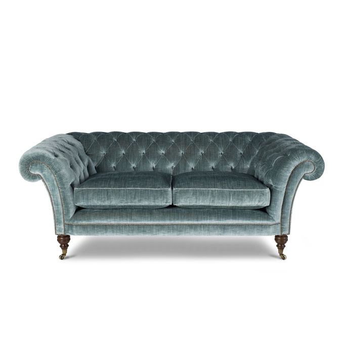A bespoke, Chesterfield style sofa upholstered in a teal silk velvet fabric.