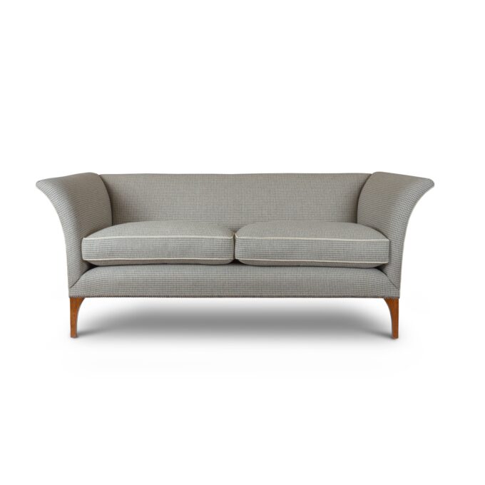 A luxurious high-backed sofa in a contemporary grey houndstooth fabric.