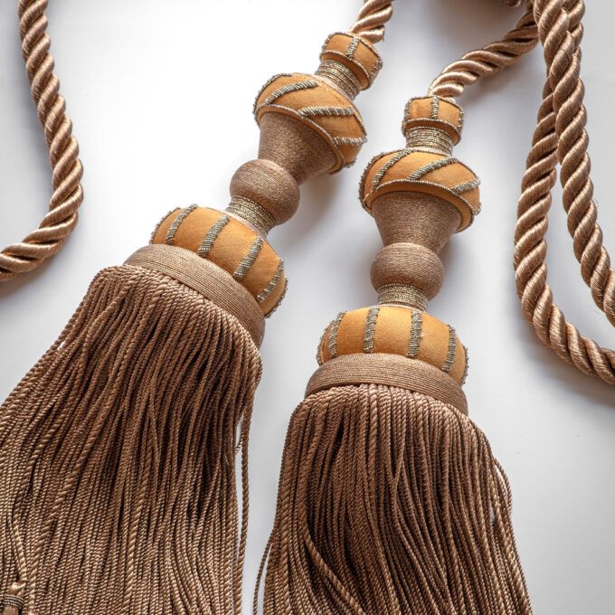 A luxury double curtain tie back in a saffron wool with metallic details..