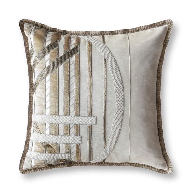 A cream hand embroidered designer cushion with an art deco design.