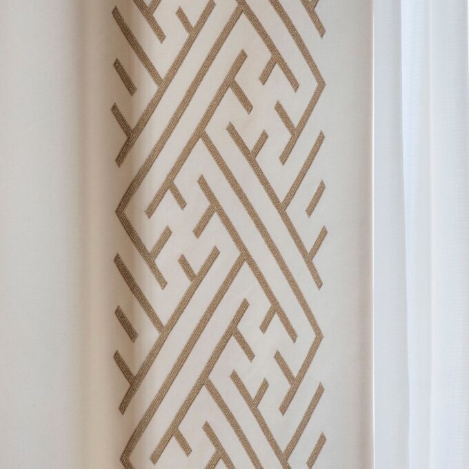 Geometric, art deco style hand embroidery on cream wool drapes.