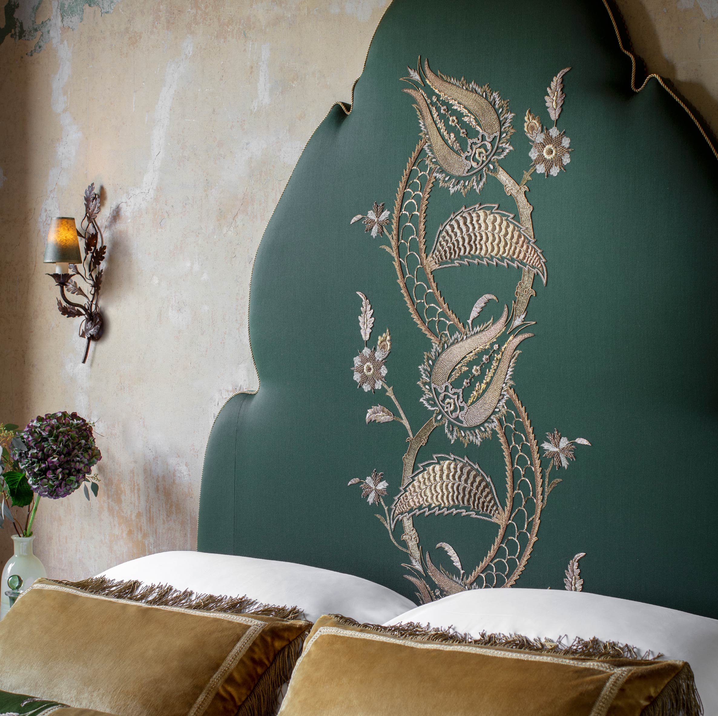 Topkapi headboard in Eriskay wool - Verde with Salome embroidery, bespoke cushions and Woodbury wall light - Beaumont & Fletcher