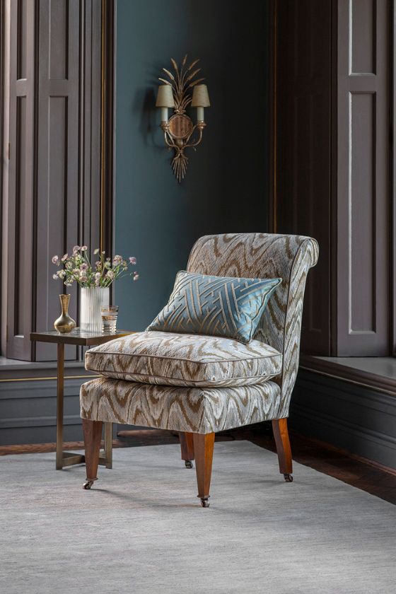 An elegant chair upholstered in a chic flame stitch fabric in tones of blue and green