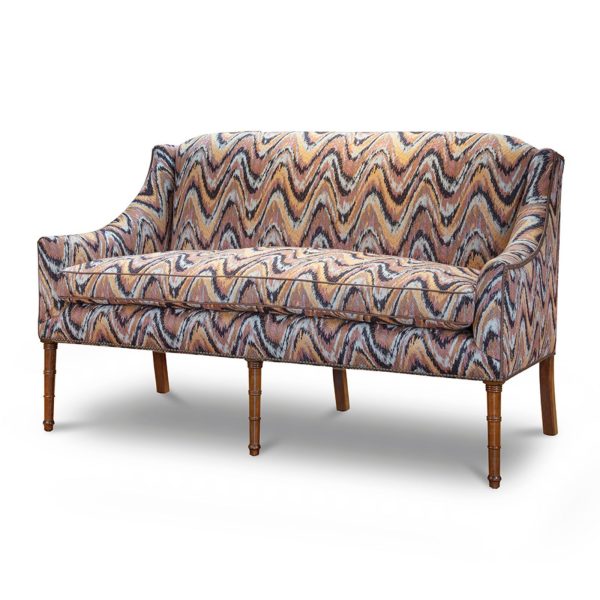 A small, elegant sofa upholstered in a modern pink flame stitch fabric