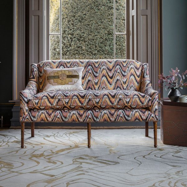 A small, elegant sofa upholstered in a modern pink flame stitch fabric
