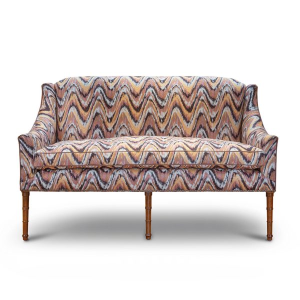 A small, elegant sofa upholstered in a modern pink flame stitch fabric