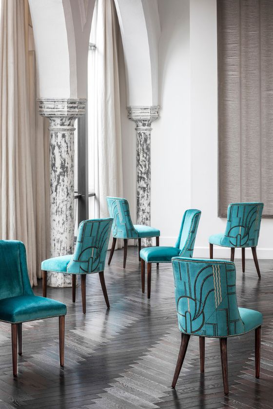 Luxurious upholstered velvet dining chairs with an Art Deco inspired embroidery design on the back 