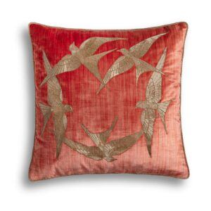 A red silk velvet cushion with a striking hand embroidered circle of birds on the front